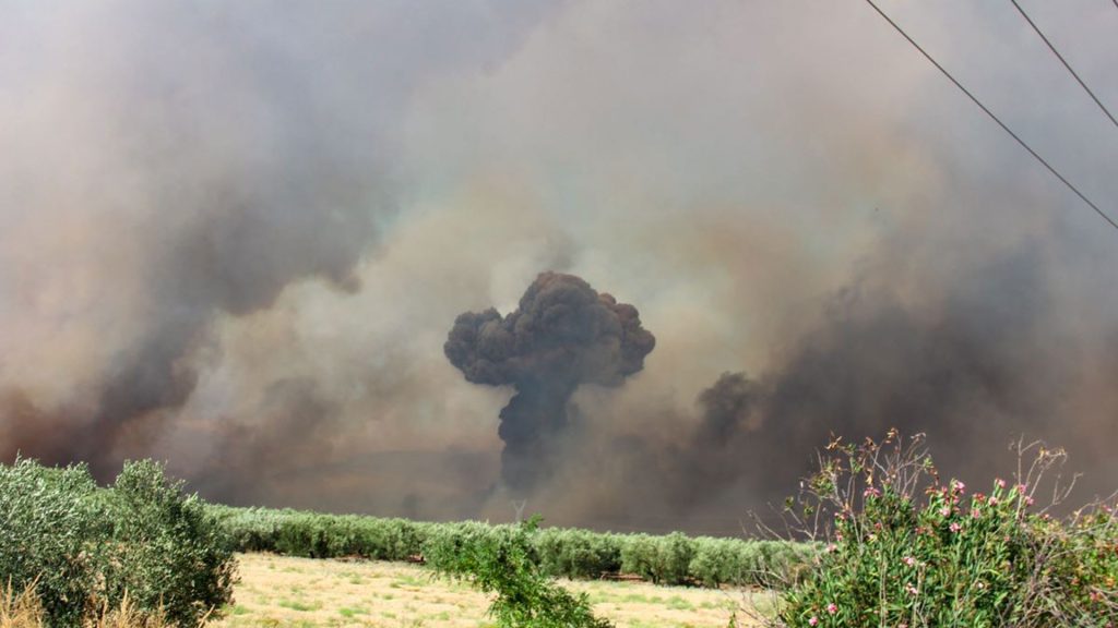 Wildfire near munitions depot causes evacuation of nearby town; explosions heard